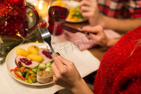 节日、食物和庆祝概念-女人吃圣诞晚餐和吃东西的特写。女人吃圣诞晚餐的特写