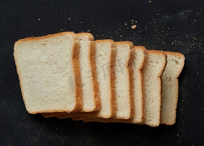 全黑摄影照片_黑底分离的黑面包和白面包切片。用来做三明治的切片面包。切成片的黑面包