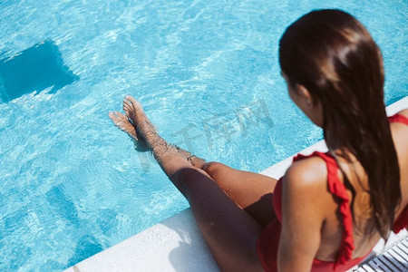 享受旅行摄影照片_美丽的女人享受游泳池在酒店
