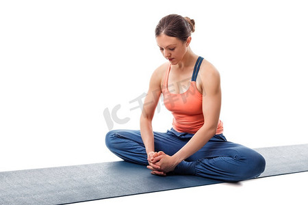 美丽的运动适合妇女实践瑜伽体位Baddha konasana约束角度姿势孤立在白色。Woman practices yoga asana Baddha konasana