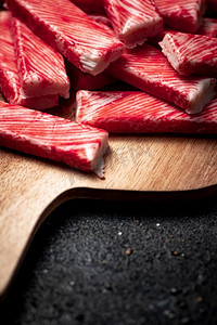 蟹肉放在木板上。黑色背景。高质量的照片。蟹肉放在木板上。 