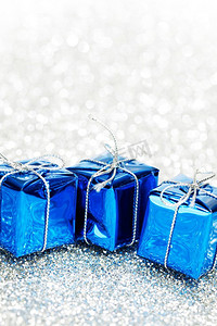 生日小卡片摄影照片_带有装饰性节日礼物的小盒子，以银色波克为背景