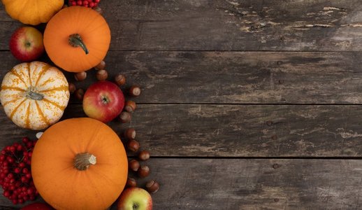 秋收静物以南瓜、苹果、榛子为木质背景，俯瞰。木桌上的秋收