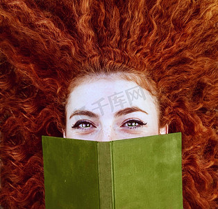 年轻的红发女人被一本书盖住了