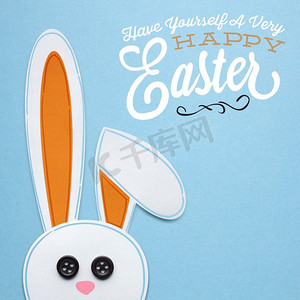 一只兔子的创造性复活节概念照片由纸制成在蓝色背景。