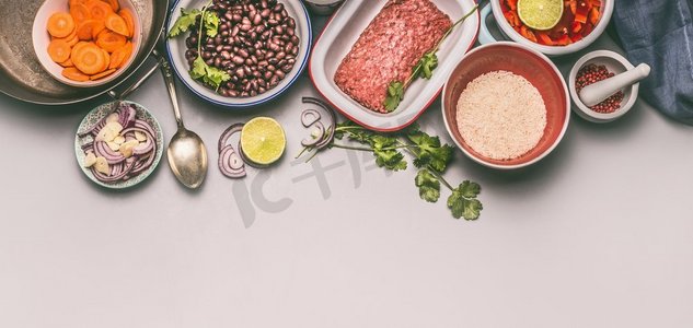 肉俯视摄影照片_带有烹饪材料的碗，与豆子、碎肉、米饭和各种切好的蔬菜在灰色背景上平衡一盘饭，俯视