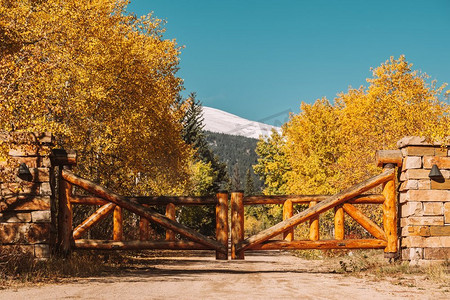 在美国科罗拉多州秋天晴天的未铺设的道路上的原木制成的乡村大门。 