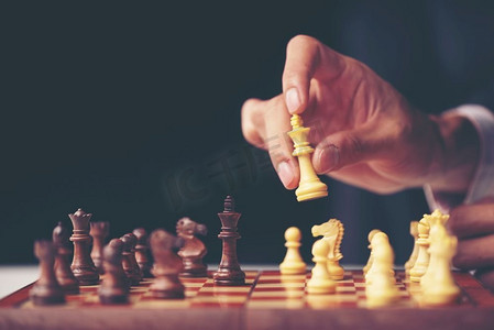 生意人之手在比赛中移动棋手成功下棋。战略、管理或领导概念