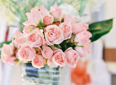 粉红色玫瑰花/柔和的颜色粉红色玫瑰开花春天花束在桌子模糊背景