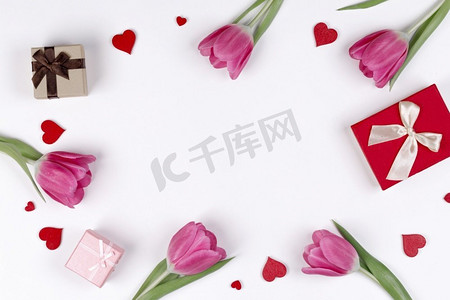 粉色郁金香礼物和心形边框与白色背景隔绝的复制空间情人节概念。粉色郁金香礼物和白色心形