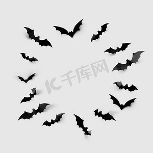 万圣节装饰概念-黑色纸蝙蝠在灰色背景上围成一圈。黑色万圣节蝙蝠围成一圈