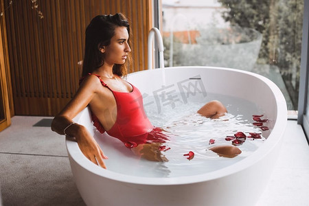 妇女沐浴和放松在现代浴缸