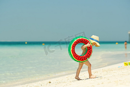 海滩上戴着游泳圈的蹒跚学步的男孩。海滩上戴着充气游泳圈的两岁幼儿