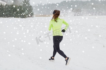 健身，运动和健康的生活方式概念—妇女在冬季户外跑步。冬天户外跑步的女人