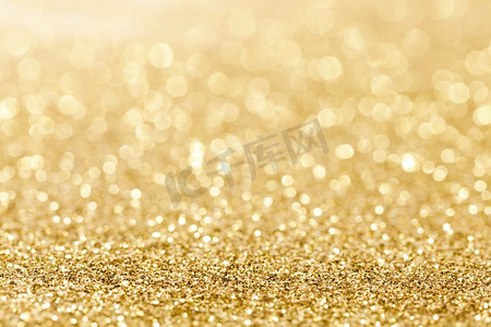 金色灯光背景摄影照片_闪亮的金色波克闪闪发光的抽象背景，圣诞新年晚会庆祝概念。闪亮的金色灯光背景