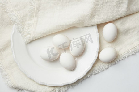 在白布背景上的盘子上代表了几个白色的鸡蛋。复活节的背景不错。复活节概念..背景上的彩蛋设计