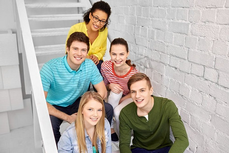 友谊和人际概念—微笑的青少年朋友或学生挂在楼梯上。十几岁的朋友或学生在楼梯上闲逛