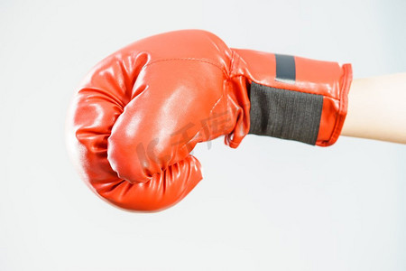无法辨认的运动女子戴着红色拳击手套。工作室拍摄在黑暗背景。戴拳击手套的女人