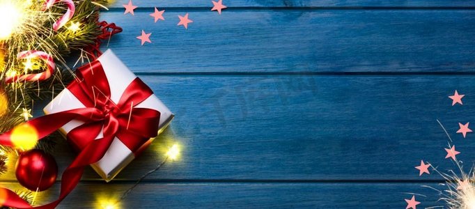 圣诞节或新年礼物与火花和节日冷杉树在蓝色桌子在晚上。圣诞或新年礼物