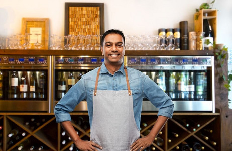 人，工作和职业概念—微笑的印度酒吧男招待或服务员围裙在葡萄酒酒吧背景微笑的印度酒保或服务员在葡萄酒酒吧