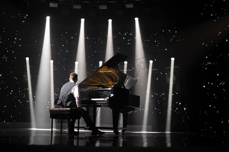 音乐会摄影照片_聚光灯下舞台上的钢琴。在音乐会之前
