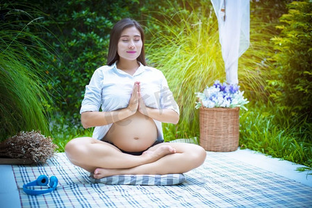 孕妇在户外做瑜伽。运动与冥想概念