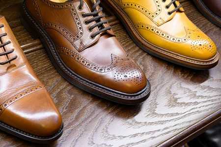 棕色全粒面皮鞋在木制显示在男鞋精品店。男士鞋业精品店