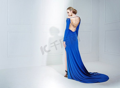 优雅的女人穿着一件豪华的蓝色礼服
