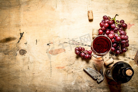葡萄和软木塞的红酒。在木制背景上。葡萄和软木塞的红酒。