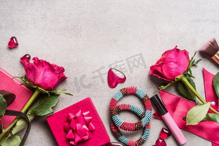 粉色女人情人节或约会配饰：一束玫瑰，心形，礼物，化妆，皇冠，手镯。俯视图，边框