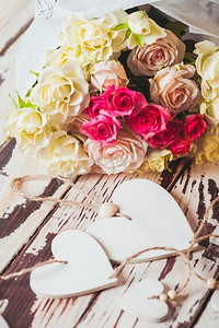 放在木板上的豪华玫瑰花束和木制的心形图案。一束玫瑰花