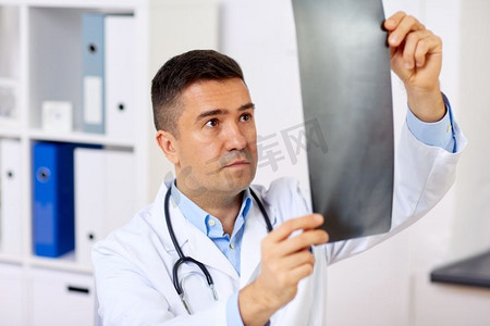 男背摄影照片_医学、保健和人的概念-在医院接受x光检查的男医生或外科医生。在医院接受X光检查的男医生或外科医生