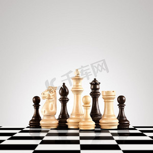 战略和领导理念；黑白木质棋子人物站在棋盘上准备下棋。