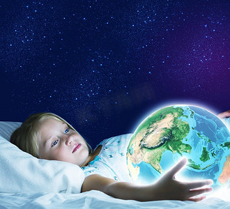 晚安。女孩躺在床上，手里拿着地球。这张图片的要素由美国宇航局提供