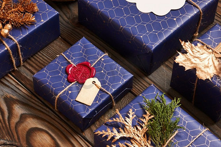 创造性地包装和装饰圣诞礼物，在木质背景的盒子里。平躺着。