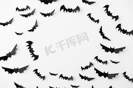 万圣节，装饰和可怕的概念—群黑色纸蝙蝠飞行在白色背景。一群黑色纸蝙蝠在白色背景