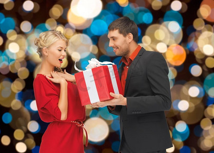 节日、情人节、圣诞节和人们概念快乐的情侣，背景是礼物。送圣诞礼物的幸福夫妻