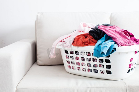 洗衣洗衣服摄影照片_在篮子里洗衣服。洗衣概念。五颜六色的干净衣服