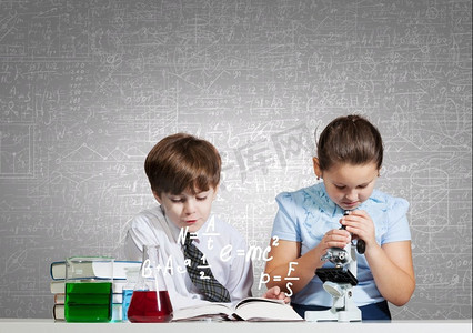 在化学课上。两个可爱的孩子在化学课上做实验