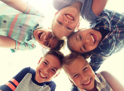 童年、休闲、友谊与人的概念——一群微笑着的孩子们的脸围成一圈。一群快乐的孩子围成一圈