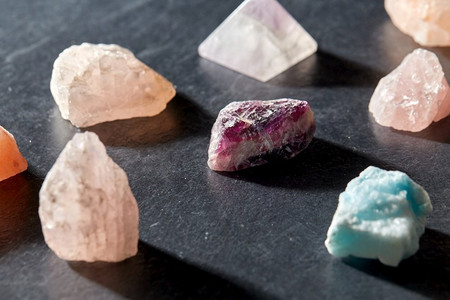 神秘科学，矿物和地质概念—石英晶体和宝石石在石板背景。石英晶体和宝石石在石板背景