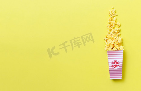 黄色背景框摄影照片_甜黄油爆米花盒在黄色背景，顶视图复制空间