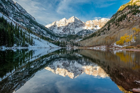 钟声摄影照片_秋天，美国科罗拉多州，栗色的钟声和栗色的湖，周围的岩石和山脉在雪中倒映。