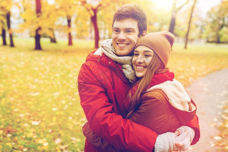 爱情，关系，季节和人的概念-秋天公园里幸福的年轻情侣拥抱。幸福的年轻情侣在秋季公园拥抱