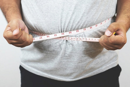 双12来来摄影照片_肥胖的男人想通过每天锻炼来减肥。并控制食物