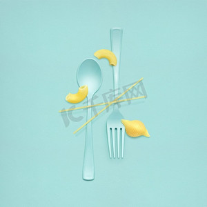 创意静物的叉子和勺子在午餐时间与生面食送达。