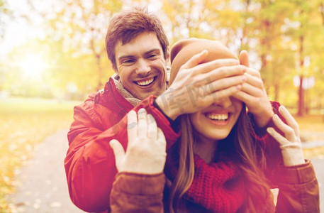 爱情，关系，季节和人的概念-快乐的年轻情侣在秋季公园玩耍。快乐的小两口在秋季公园玩得开心