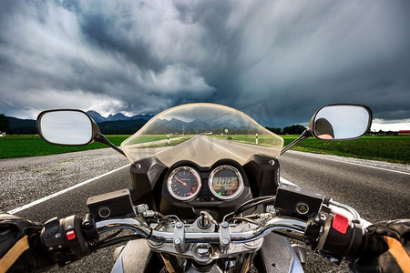 一名骑摩托车的人在闪电风暴中疾驰在路上--德国巴伐利亚州福格根塞和施万高