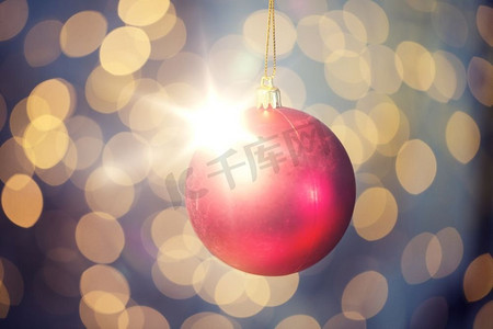 圣诞节，装饰，节日概念-金色灯光背景下的红色闪闪发亮的球的特写。红色圣诞球在金色彩灯上的特写