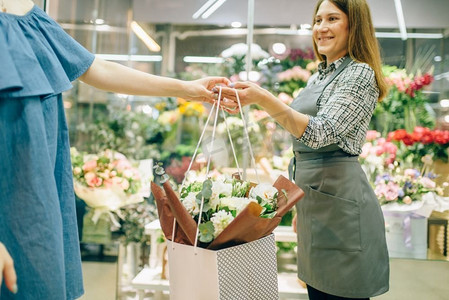 精品摄影照片_花店的经营理念，花商穿围裙，女性顾客穿花艺精品店。 